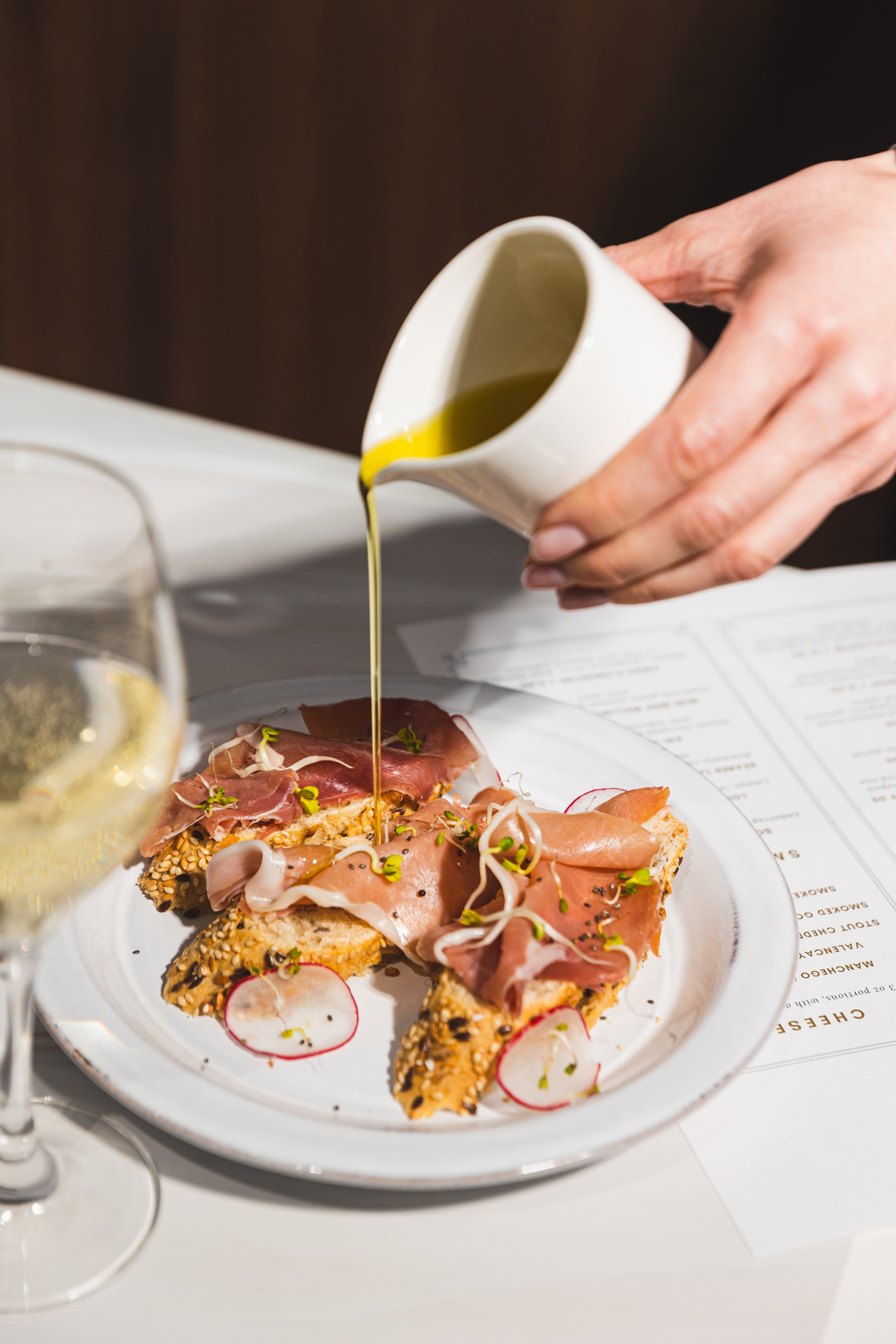 High-Flash Restaurant Dining Drizzling Oil on Prosciutto